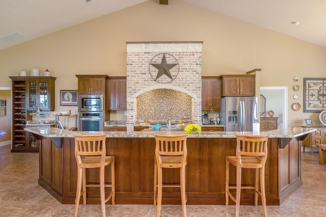 kitchen featuring a large island with sink, a kitchen bar, and stainless steel appliances