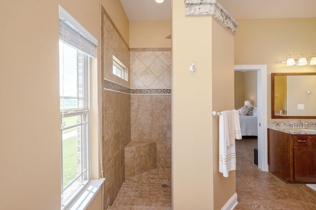 bathroom featuring vanity, tiled shower, and a healthy amount of sunlight