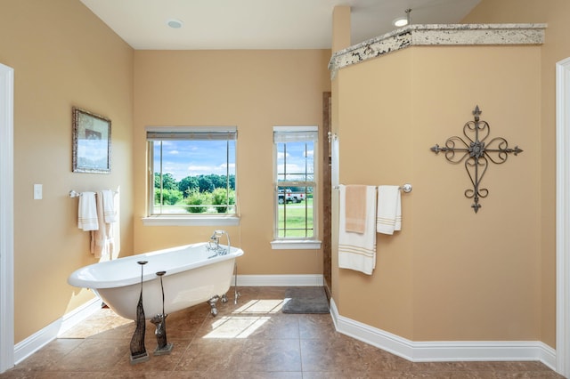 bathroom with tile patterned floors and a bath