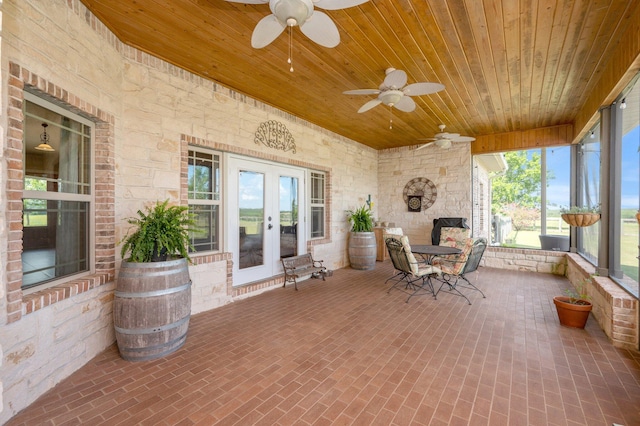 unfurnished sunroom featuring ceiling fan and wooden ceiling