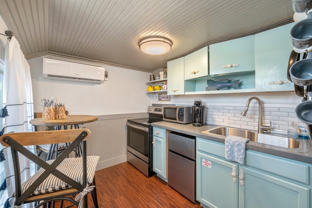 kitchen featuring appliances with stainless steel finishes, a wall unit AC, sink, tasteful backsplash, and dark wood-type flooring