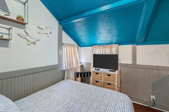 bedroom with dark wood-type flooring and vaulted ceiling with beams