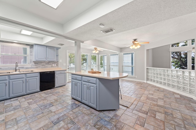 kitchen with dishwasher, a center island, sink, tasteful backsplash, and a breakfast bar