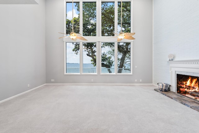 unfurnished living room featuring carpet and ceiling fan