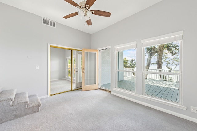 carpeted spare room featuring french doors and ceiling fan