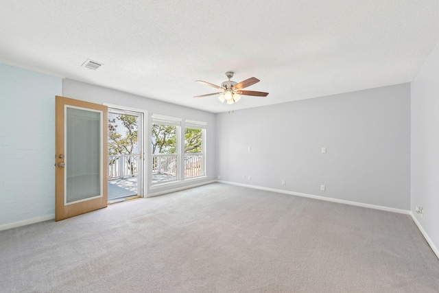 spare room featuring a textured ceiling, ceiling fan, and light carpet