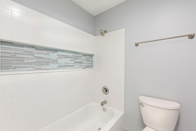 bathroom with toilet, a textured ceiling, and tub / shower combination