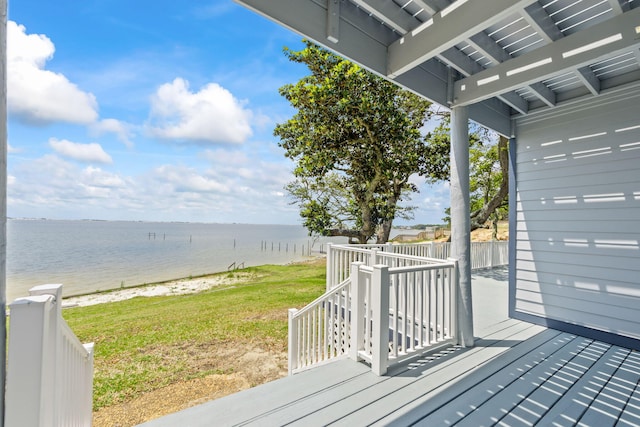 wooden terrace with a lawn, a water view, and a beach view