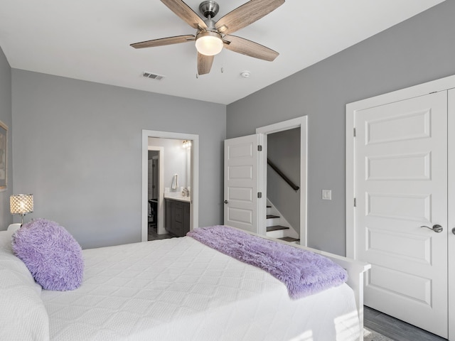 bedroom with ceiling fan, ensuite bath, and hardwood / wood-style flooring