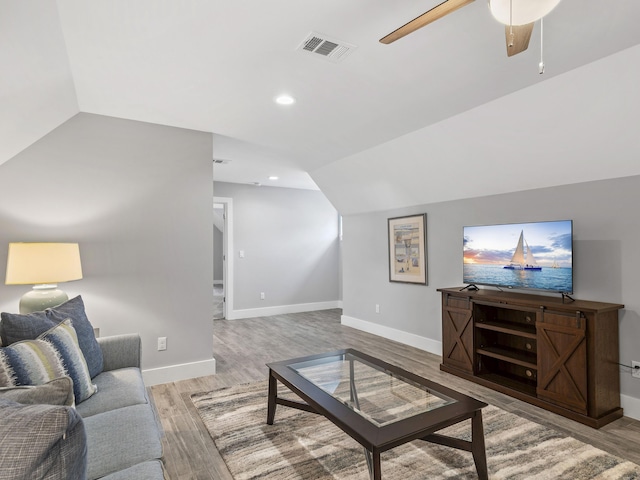 living room with wood-type flooring, ceiling fan, and lofted ceiling