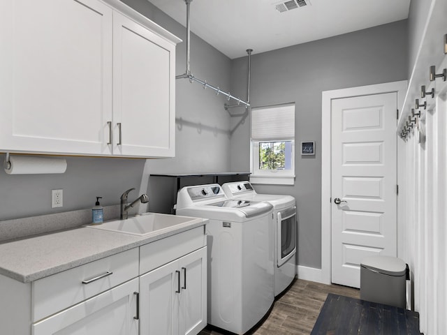 laundry room with sink, independent washer and dryer, cabinets, and dark hardwood / wood-style floors