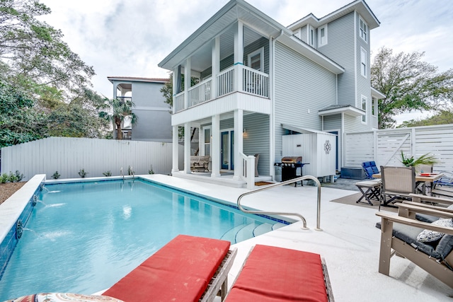 view of pool featuring a grill, pool water feature, and a patio