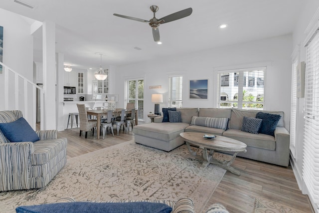 living room featuring a wealth of natural light, ceiling fan, and light hardwood / wood-style floors