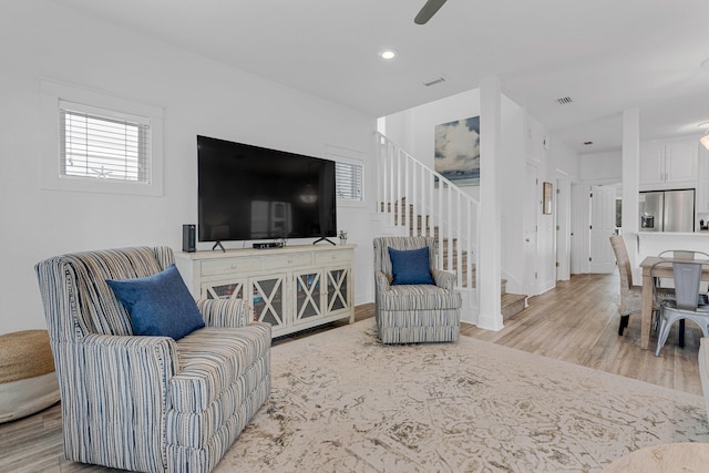 living room with ceiling fan and light hardwood / wood-style floors