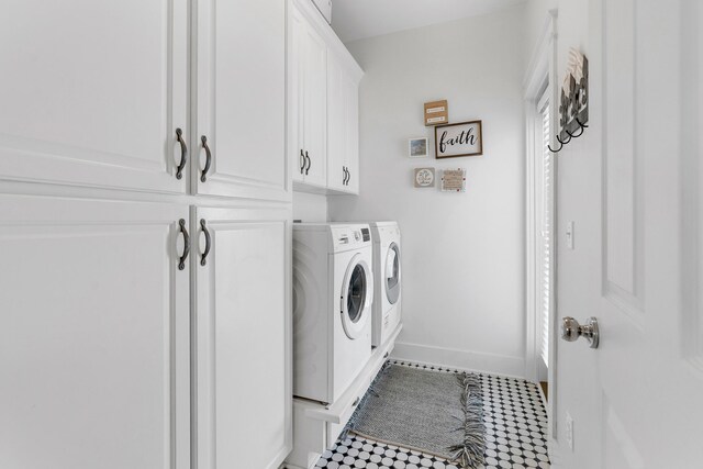 laundry room with separate washer and dryer and cabinets