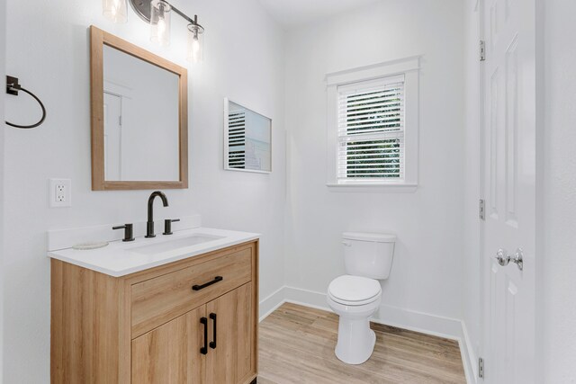 bathroom featuring wood-type flooring, vanity, and toilet