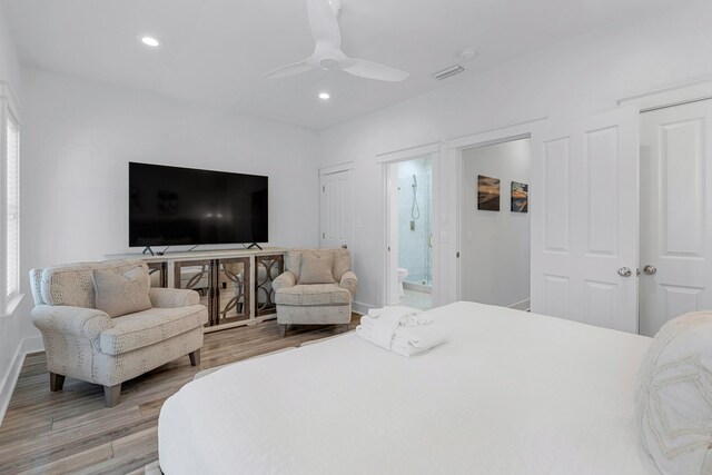 bedroom with connected bathroom, ceiling fan, and light wood-type flooring