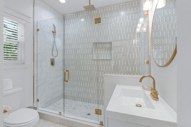 bathroom with tile patterned floors, vanity, toilet, and walk in shower