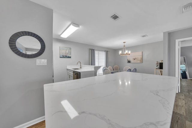 dining area with sink, light hardwood / wood-style floors, and a chandelier