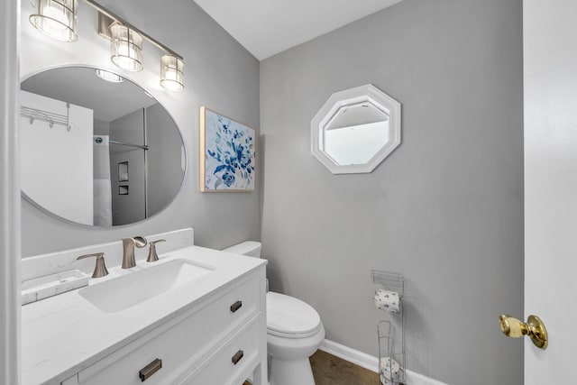 bathroom with wood-type flooring, vanity, and toilet