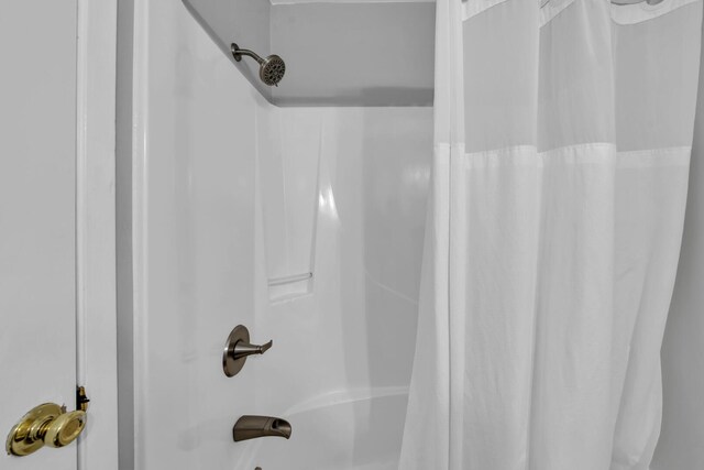 interior details featuring shower / bath combination with curtain