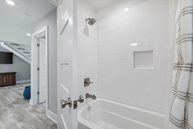 bathroom with shower / tub combo with curtain and hardwood / wood-style floors