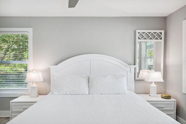 bedroom with ceiling fan and multiple windows