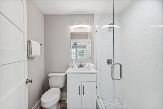 bathroom featuring ceiling fan, an enclosed shower, vanity, and toilet