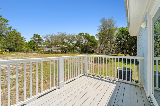 wooden deck featuring central air condition unit and a lawn