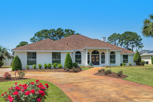 mediterranean / spanish house featuring solar panels and a front yard