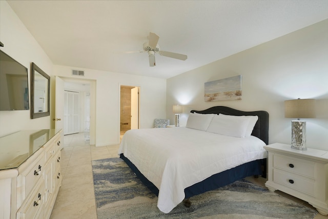 bedroom featuring ceiling fan, light tile floors, and ensuite bathroom