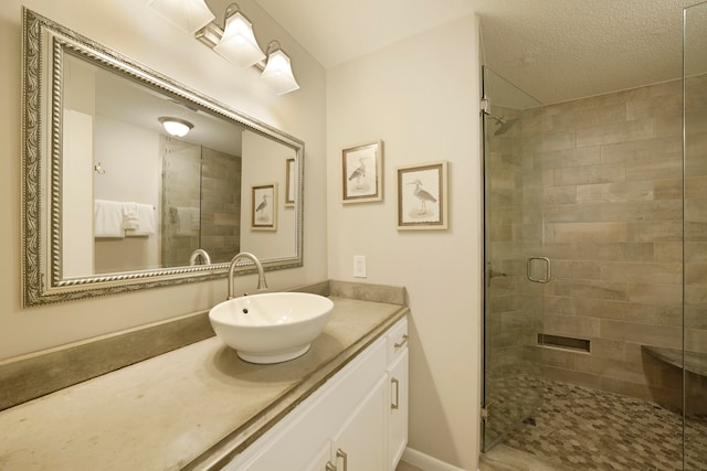 bathroom featuring walk in shower, a textured ceiling, and vanity