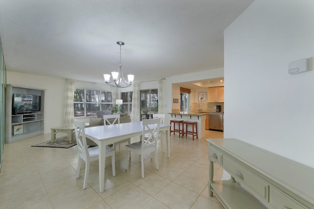 tiled dining room featuring a chandelier