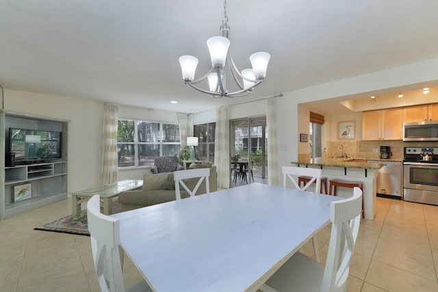 tiled dining area featuring a notable chandelier and a wealth of natural light