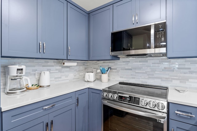 kitchen featuring tasteful backsplash, appliances with stainless steel finishes, and blue cabinetry