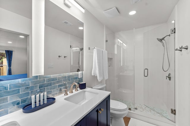 bathroom with backsplash, an enclosed shower, vanity, and toilet