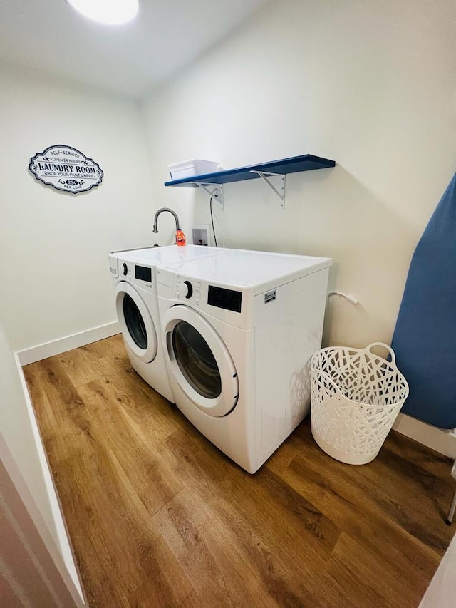 clothes washing area with light hardwood / wood-style flooring, sink, washer hookup, and washer and dryer