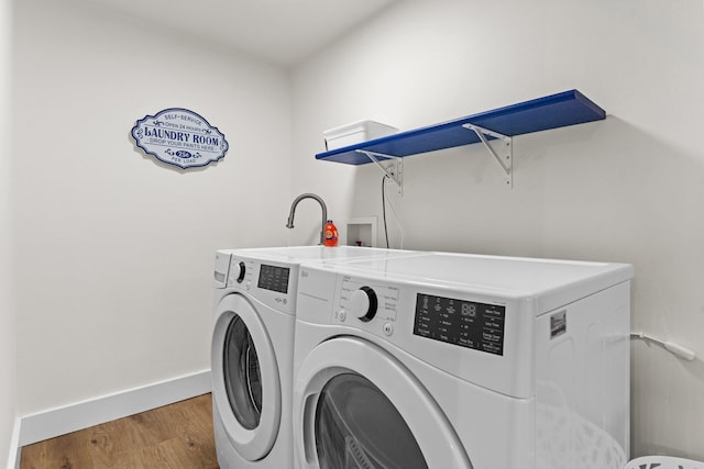 washroom featuring washing machine and dryer, light wood-type flooring, and washer hookup