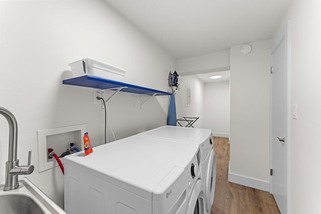 laundry room with sink, light wood-type flooring, washer hookup, and washing machine and clothes dryer