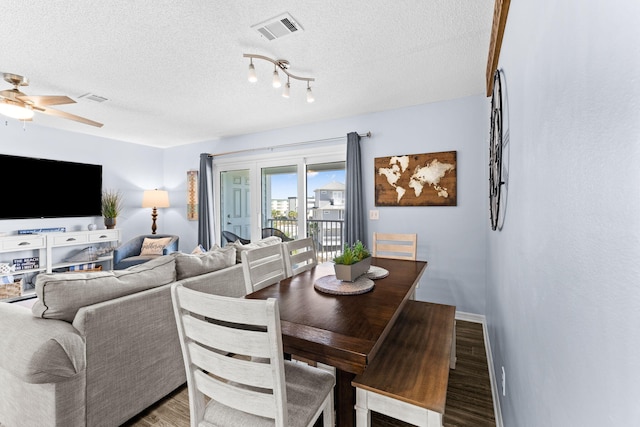 dining room with a textured ceiling, ceiling fan, hardwood / wood-style flooring, and track lighting