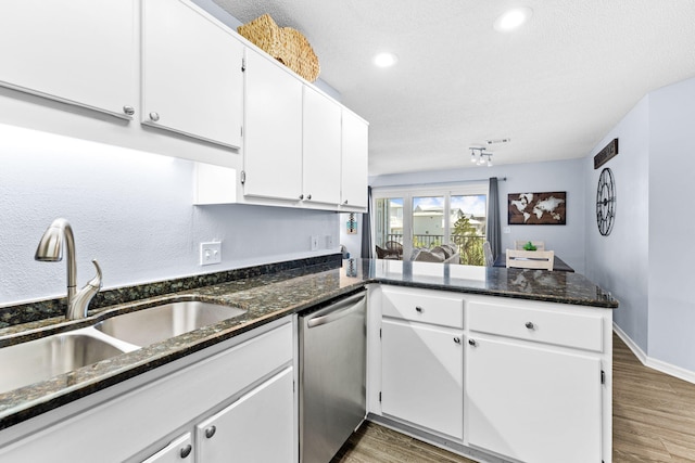 kitchen featuring white cabinets, hardwood / wood-style floors, kitchen peninsula, dark stone countertops, and dishwasher