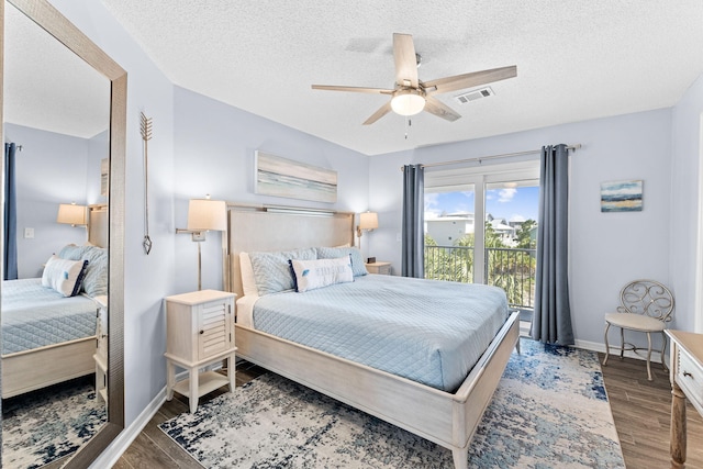 bedroom with ceiling fan, dark wood-type flooring, and a textured ceiling