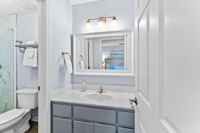 bathroom with a textured ceiling, vanity, and toilet