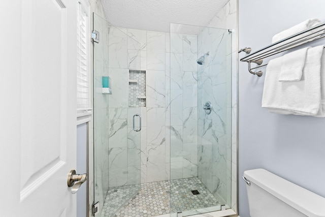 bathroom featuring a textured ceiling, an enclosed shower, and toilet