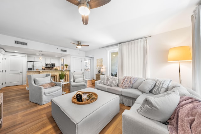 living room featuring ceiling fan and light hardwood / wood-style floors