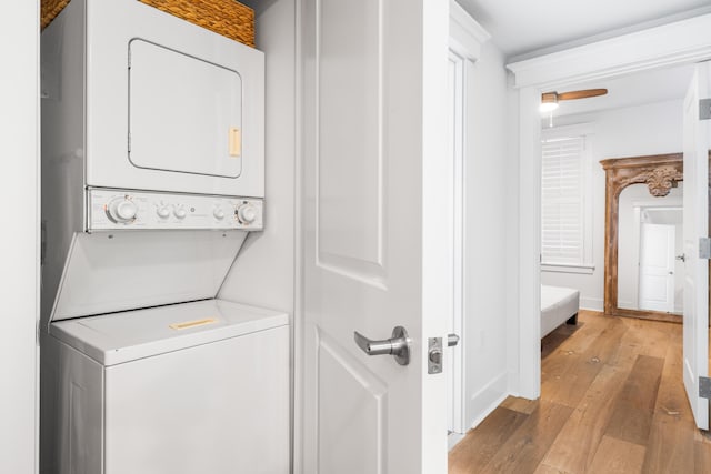 laundry area featuring light hardwood / wood-style floors, stacked washer and clothes dryer, and ceiling fan