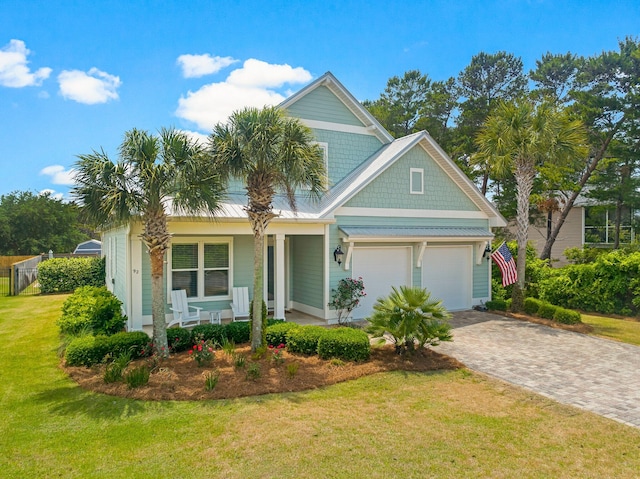 view of front of house with a garage, covered porch, and a front lawn