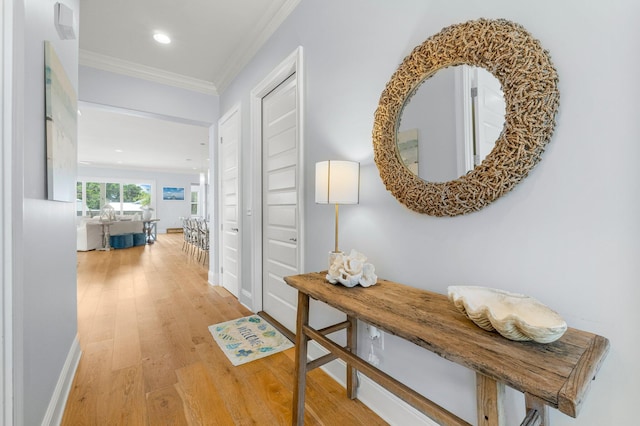 hallway with hardwood / wood-style floors and ornamental molding