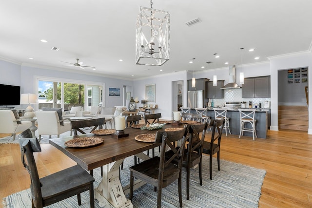 dining space featuring ornamental molding, light hardwood / wood-style flooring, and ceiling fan