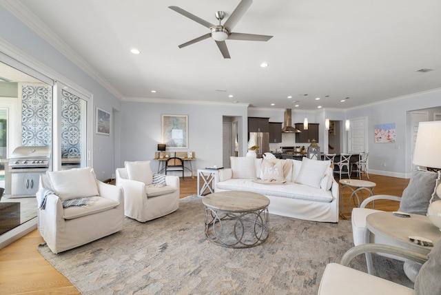 living room featuring ceiling fan, light hardwood / wood-style floors, and ornamental molding